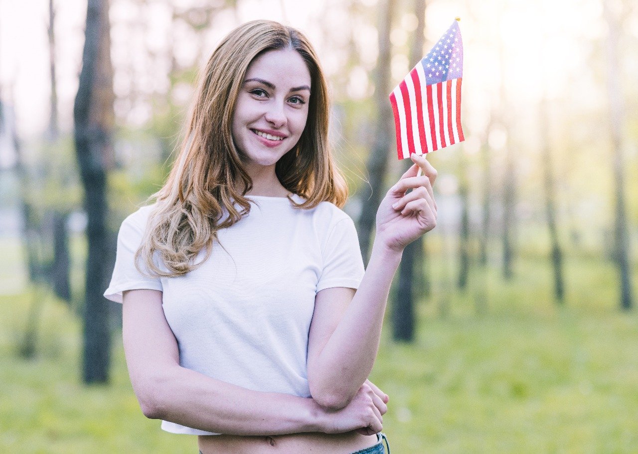 Young woman holding American flag at town hall event